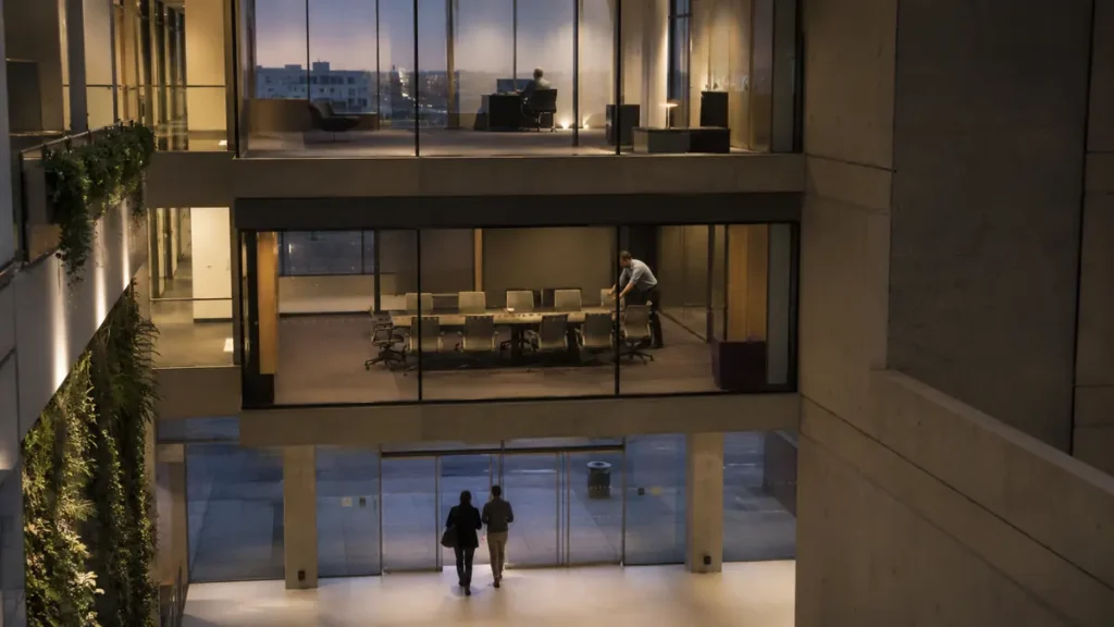 Three office levels reveal an executive, a lone manager and two workers leaving below.
